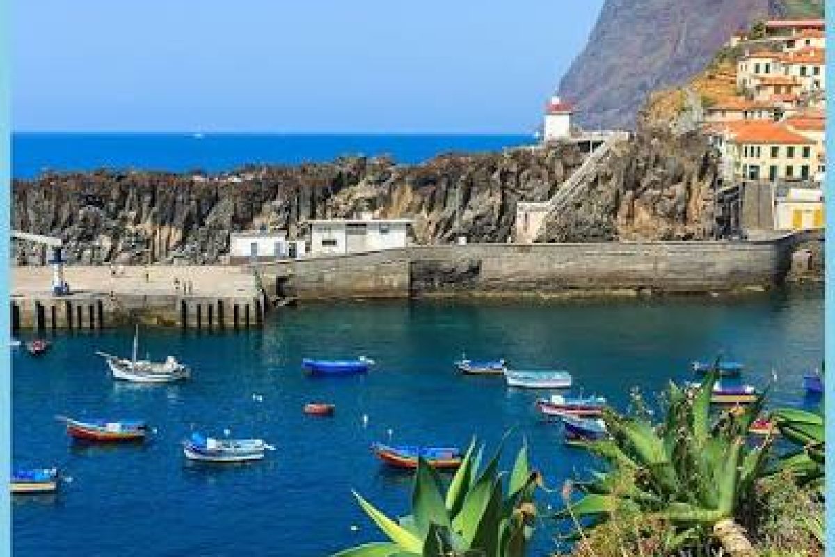 Câmara de Lobos harbour with fishing boats and the cliffs of Cabo Girão behind